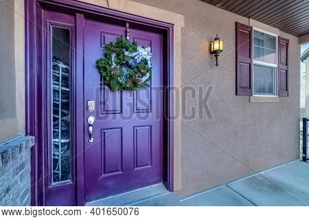 Vivid Purple Front Door With Wreath And Sidelight At The Entance Facade Of Home