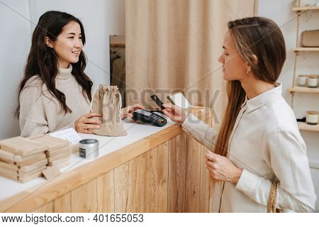 Tired Female Customer Making A Purchaise, Paying With Her Credit Card.