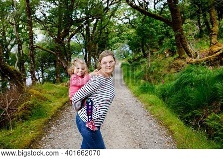 Mother Holding Little Toddler Girl In Glenveagh National Park In Ireland. Smiling And Laughing Baby 
