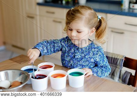 Excited Little Toddler Girl Coloring Eggs For Easter. Cute Happy Child Looking Surprised At Colorful