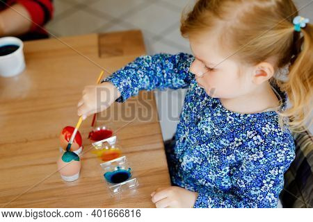 Excited Little Toddler Girl Coloring Eggs For Easter. Cute Happy Child Looking Surprised At Colorful