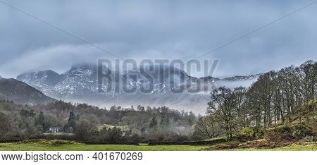 Stunning Landscape Image Of View From Elterwater Across Towards Langdale Pikes Mountain Range On Fog