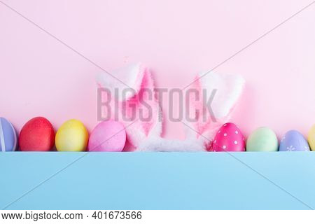 Easter Rabbit Flaffy Ears And Colored Easter Colored Eggs, Top View On Pink And Blue Plain Minimal B