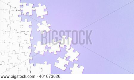 white puzzle pieces on pupple background with copyspace
