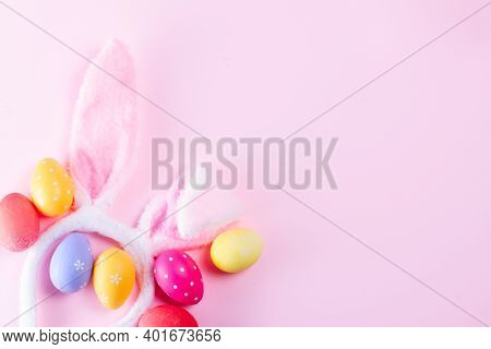 Easter Rabbit Flaffy Ears And Colored Easter Eggs Frame On Pink Background, Flat Lay With Copy Space