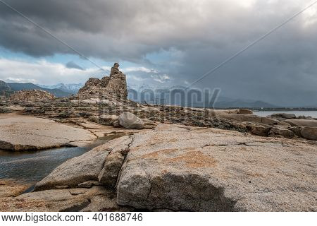 Ancient Genoese Tower At Punta Caldanu Near Lumio In The Balagne Region Of Corsica With The Snow Cap