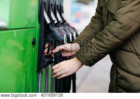 Close-up Of Hands Of Woman At Self-service Gas Station, Hold Fuel Nozzle And Refuel The Car With Pet