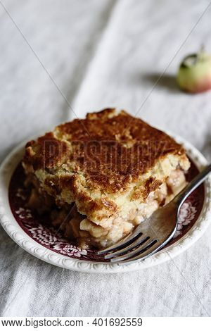 Apple And Cheese Cobbler Crisp. Cobbler Or Crumble Dessert With Apples On Plate On Beige Linen Table