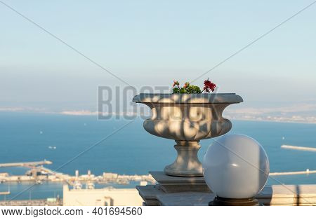 A Large Stone Decorative Pot With Geraniums And A White Lantern On The Upper Terrace Of The Bahai Ga