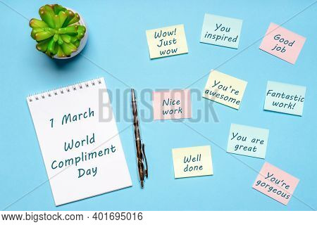 Happy World Compliment Day. Office Desk With Plant, Notebook, Pen And Paper Slips With Compliments T