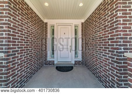 Portico At The Entrance Of House With White Front Door Between Sidelights