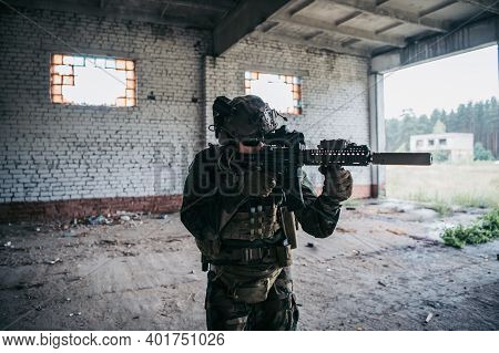 Soldier In Full Us Marsoc Armed With Assault Rifle Run Through The Abandoned Building. Military Clas