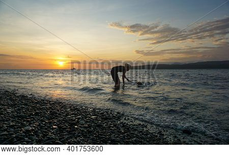Banyuwangi, Indonesia - May 14, 2020 : A Woman Playing With The Dogs At Watudodol Beach Banyuwangi I