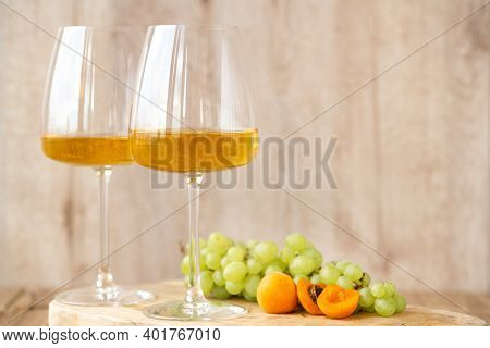 Amber Or White Wine With Fruit. Poured Glass With Wine Surrounded By Grapes, Peaches And Pears On A 