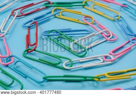 Chain Made Of Paper Clips On Blue Background. Teamwork And Cooperation Concept. Soft Focus.
