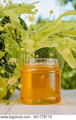 Jar Of Fresh Sweet Linden Honey And Linden Flowers On White Wooden Table