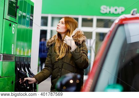 Young Caucasian Woman At Self-service Gas Station, Hold Fuel Nozzle And Refuel The Car With Petrol, 