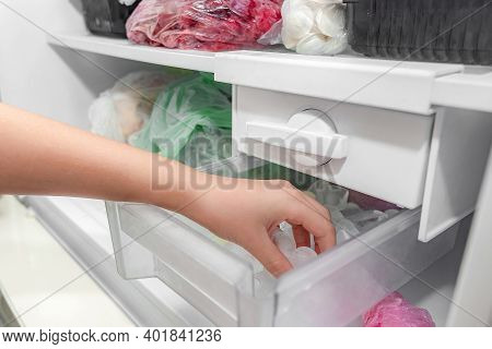 The Girl Takes Ice From The Ice Maker Of The Freezer For Cooling Drinks.