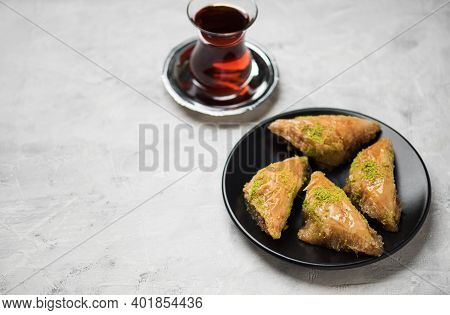 Baklava. Traditional Turkish Desserts Baklava With Turkish Tea. Crispy Pistachio Baklava On Black Pl