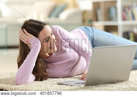 Happy Woman Watching Media On Laptop Lyng On The Floor At Home