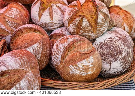 Big Wicker Basket Ful Of Fressh Hot Loafs Of Bread For Sale At The Market Place One Holiday Morning.