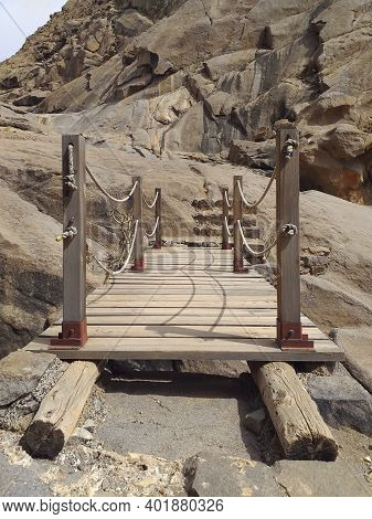 Close Up Of Rustic Wooden Bridge In Arid Ravine With Rock Formations. Hanging Structure Of Old Wood 