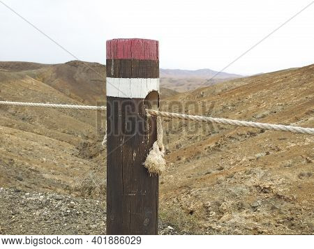 Close Up Of Round Wooden Post With Rope To Delimit The Path. High Mountain Trail Marking With Wooden