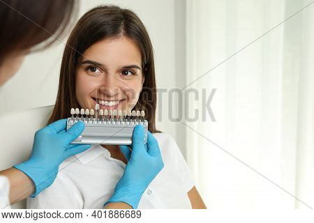 Doctor Checking Young Woman's Teeth Color In Clinic. Cosmetic Dentistry