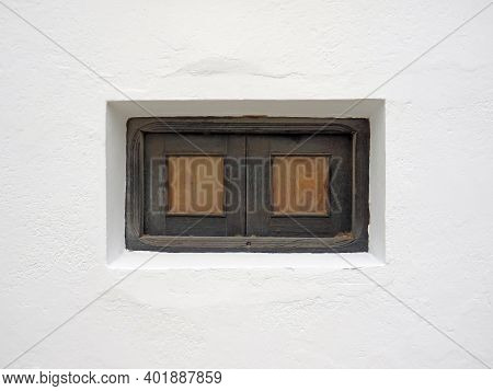 Small Vintage Wooden Window With Grate In White Lime Wall. Old Window On White Cement Wall. Architec
