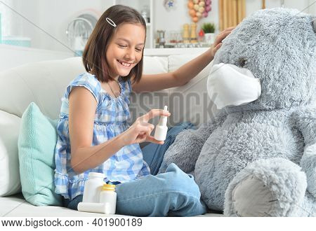 Girl Playing Doctor With Toy Bear In Facial Mask