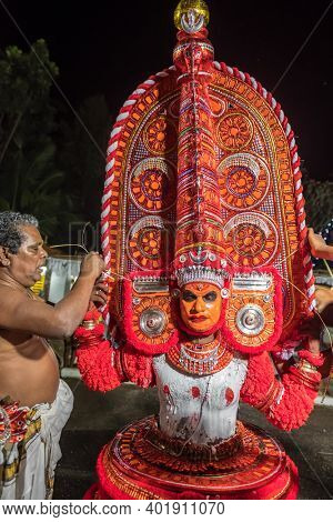Payyanur, India - December 5, 2019: Theyyam artist preparing to perform during temple festival in Payyanur, Kerala, India. Theyyam is a popular ritual form of worship in Kerala, India