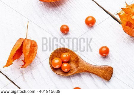 Physalis On Wooden Stump. Ripe Berries Of Autumn Red Physalis Fruit. Berries Fruit. Physalis Or Chin