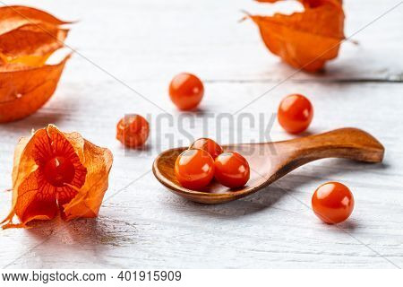 Physalis On Wooden Stump. Ripe Berries Of Autumn Red Physalis Fruit. Berries Fruit. Physalis Or Chin
