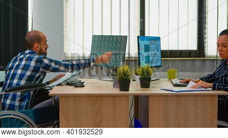 Handicapped Paralysed Businessman In Wheelchair Analysing Economy Data Taking Notes Making Financial