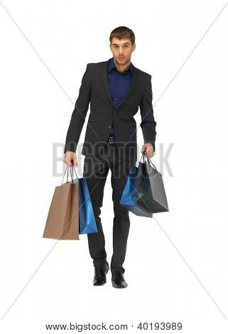 Foto de hombre guapo en traje con bolsas de compras.