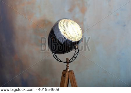 Stylish Lamp On Tripod In Room. Tripod Light Projector. Decorative Light Projector Stands Against A 