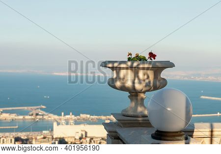 A Large Stone Decorative Pot With Geraniums And A White Lantern On The Upper Terrace Of The Bahai Ga