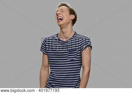Portrait Of Unhappy Caucasian Teen Boy. Depressed Teenage Boy Is Crying On Gray Background. Stress, 