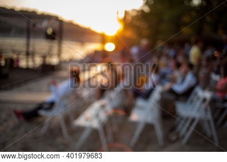 People Are Watching A Concert Of Classical Music. Blurred Young And Adult Women And Men And Other Pe