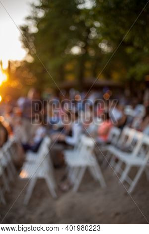 People Are Watching A Concert Of Classical Music. Blurred Young And Adult Women And Men And Other Pe
