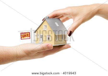 Atingindo uma casa com sinal de imóveis vendidos