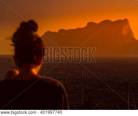 Woman With A Thoughtful Back While Enjoying A Beautiful View Of The Sea And The Penon De Ifach At Su