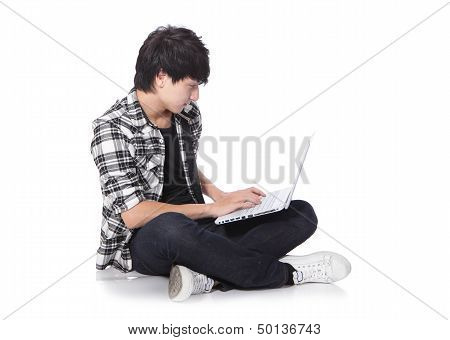 Young Man Sitting On The Floor With Laptop