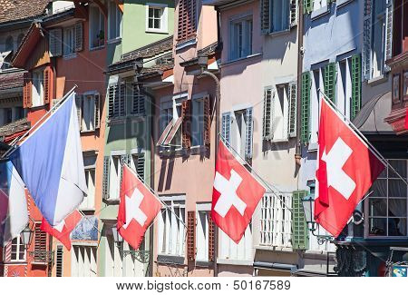 Gamle gade Augustinergasse i Zürich dekoreret med schweiziske flag