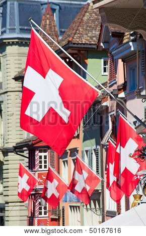 Gamle gade Augustinergasse i Zürich dekoreret med schweiziske flag