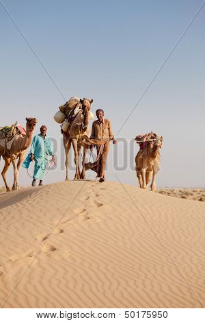 Caravan With Bedouins And Camels In Desert