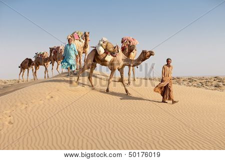 Caravan With Bedouins And Camels In Desert