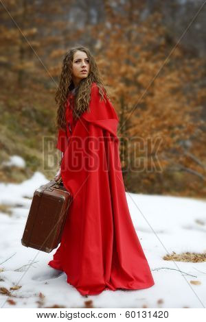 beautiful woman with red cloak and suitcase