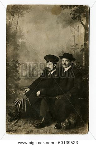 MOSCOW, RUSSIA - CIRCA 1900s: An antique photo shows studio portrait of a two men in overcoats and hats