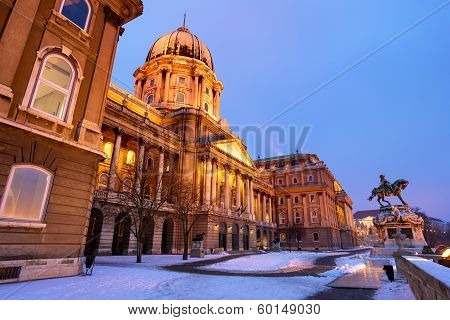 Snowy Buda Castle In Budapest Under A Foggy Blue Sky